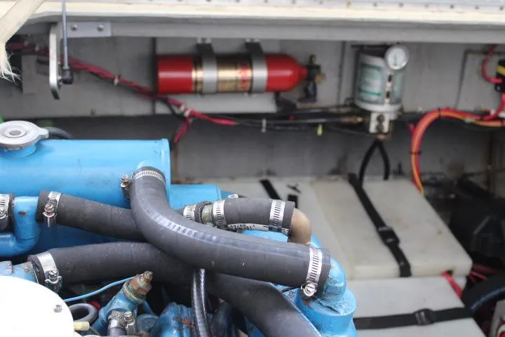 Slide: The Image of Engine compartment of a 1988 Tollycraft 30 Sport Cruiser with visible hoses and fire extinguisher. - 24