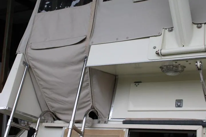Slide: The Image of 1988 Tollycraft 30 Sport Cruiser with beige canvas cover and stainless steel ladder. - 25
