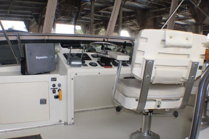 Slide: The Image of 1988 Tollycraft 30 Sport Cruiser helm with captain's chair and navigation controls. - 26