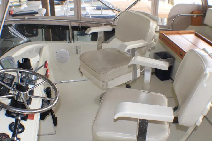 Slide: The Image of 1988 Tollycraft 30 Sport Cruiser helm with dual captain chairs and steering wheel. - 27