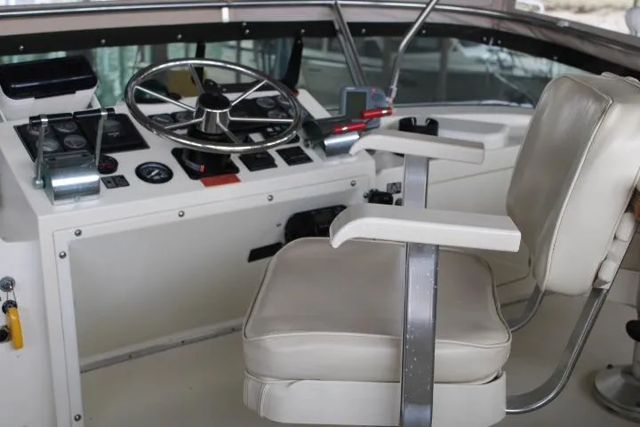 Slide: The Image of 1988 Tollycraft 30 Sport Cruiser helm with steering wheel and captain's chair. - 30