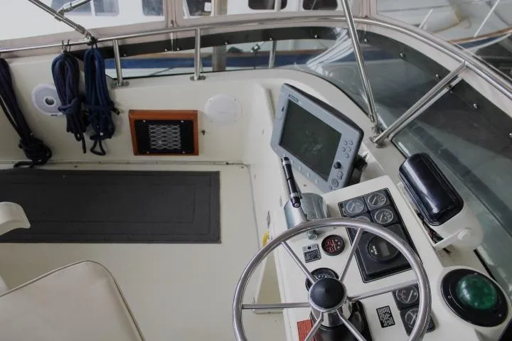 Slide: The Image of 1988 Tollycraft 30 Sport Cruiser helm with steering wheel, gauges, and navigation equipment. - 31