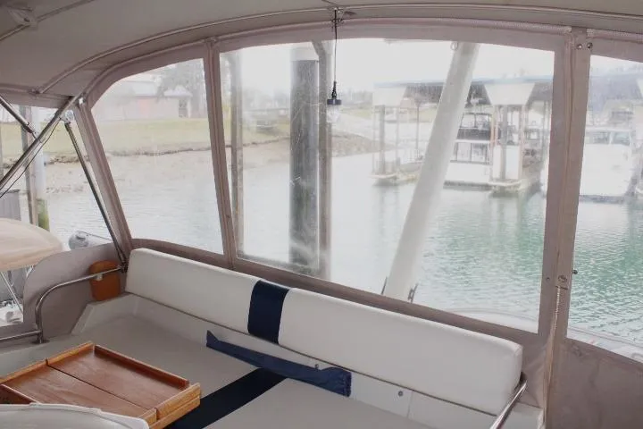 Slide: The Image of 1988 Tollycraft 30 Sport Cruiser interior with marina view through large windows. - 38