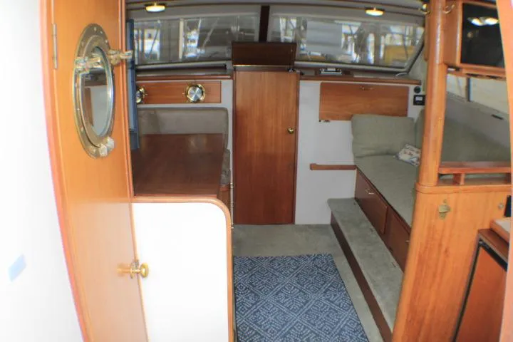 Slide: The Image of 1988 Tollycraft 30 Sport Cruiser interior with wood accents and seating area. - 42