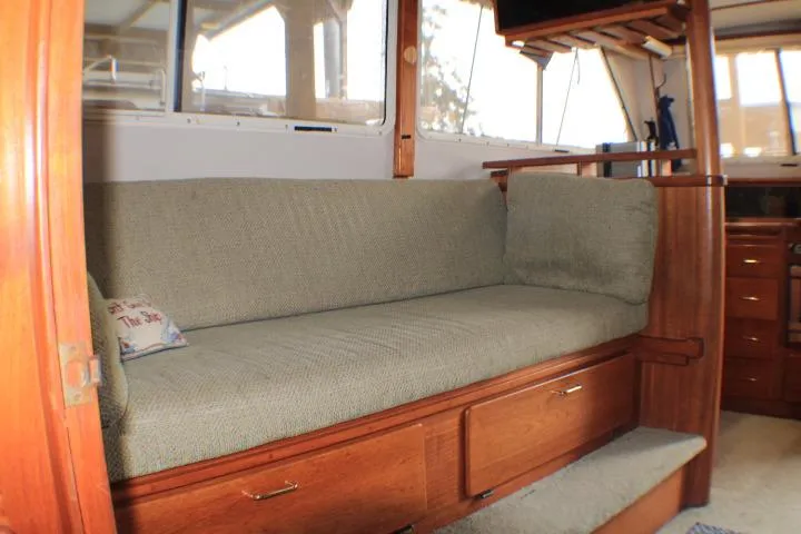 Slide: The Image of Interior of 1988 Tollycraft 30 Sport Cruiser with cushioned seating and wooden cabinetry. - 43