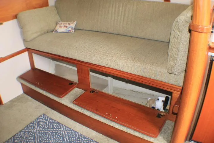Slide: The Image of 1988 Tollycraft 30 Sport Cruiser interior with cushioned seating and wooden storage compartments. - 44