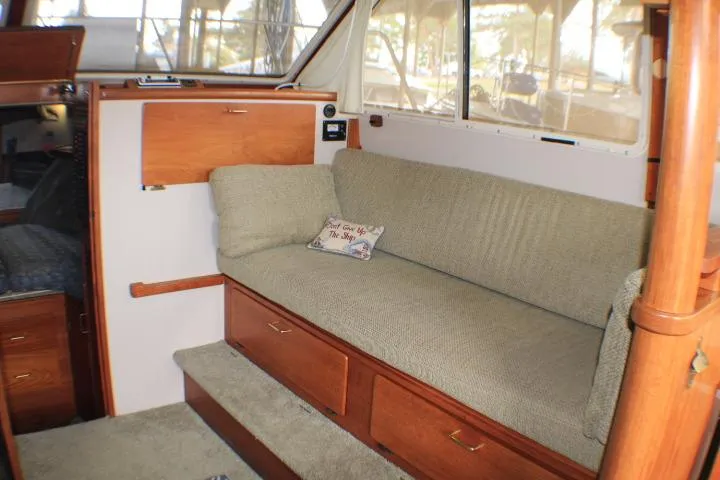 Slide: The Image of Interior of 1988 Tollycraft 30 Sport Cruiser with cushioned seating and wooden cabinetry. - 45