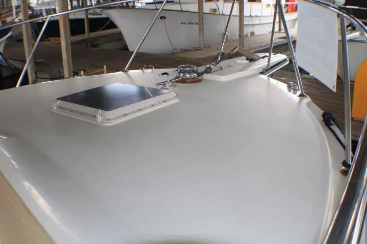 Slide: The Image of 1988 Tollycraft 30 Sport Cruiser deck with hatch and railing in marina setting. - 5