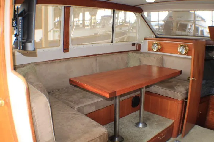 Slide: The Image of 1988 Tollycraft 30 Sport Cruiser interior with cozy dining area and wooden table. - 51