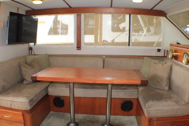 Slide: The Image of Interior of 1988 Tollycraft 30 Sport Cruiser with cozy seating and wooden table. - 52