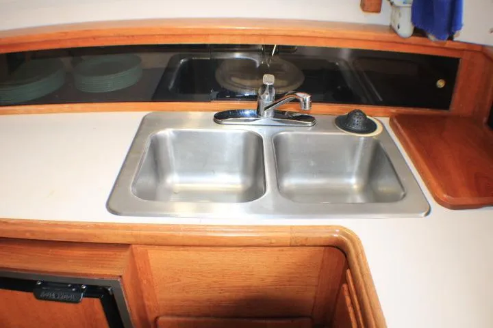 Slide: The Image of 1988 Tollycraft 30 Sport Cruiser kitchen with double sink and wooden cabinetry. - 56