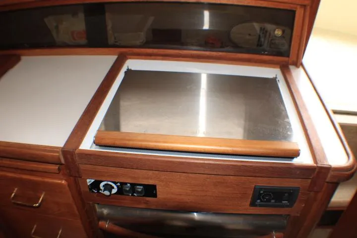 Slide: The Image of 1988 Tollycraft 30 Sport Cruiser kitchen area with wooden cabinetry and built-in stove. - 58