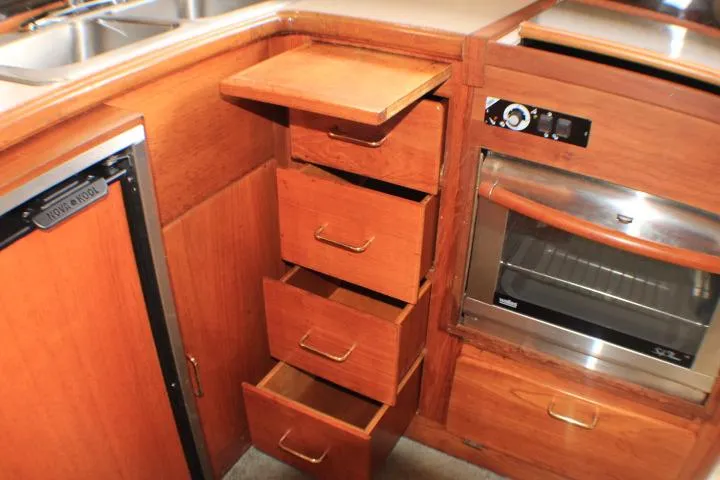 Slide: The Image of 1988 Tollycraft 30 Sport Cruiser kitchen with wooden cabinets, drawers, and built-in oven. - 63