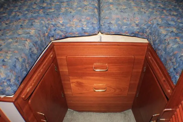 Slide: The Image of 1988 Tollycraft 30 Sport Cruiser cabin with wooden storage drawers and patterned bedding. - 66