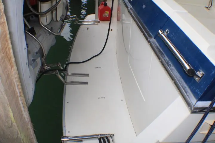 Slide: The Image of 1988 Tollycraft 30 Sport Cruiser docked, showing deck details and railing. - 9