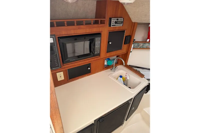 Slide: The Image of 2006 Carolina Classic 28 boat interior with kitchenette, microwave, and sink. - 17