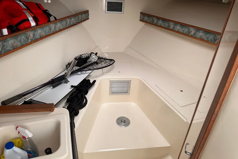 Slide: The Image of 2006 Carolina Classic 28 cabin interior with fishing gear and cleaning supplies. - 19