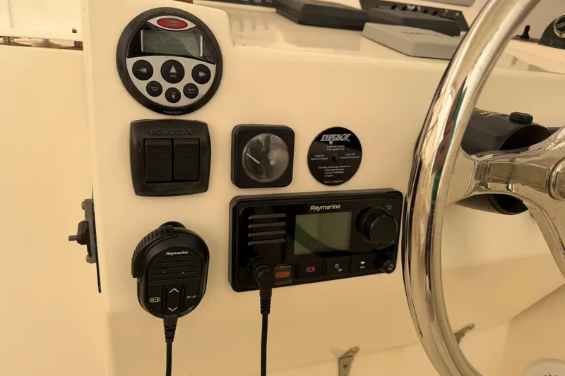 Slide: The Image of Control panel of a 2006 Carolina Classic 28 boat with steering wheel and electronics. - 20