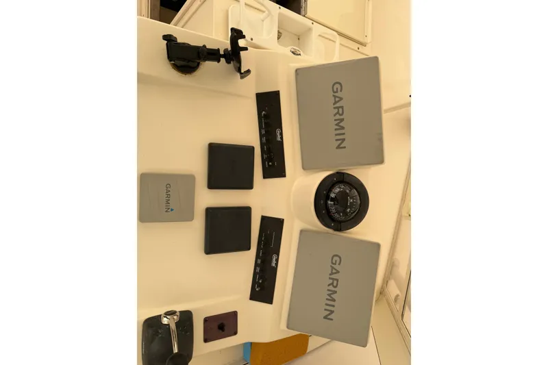 Slide: The Image of 2006 Carolina Classic 28 boat dashboard with Garmin navigation equipment and compass. - 21