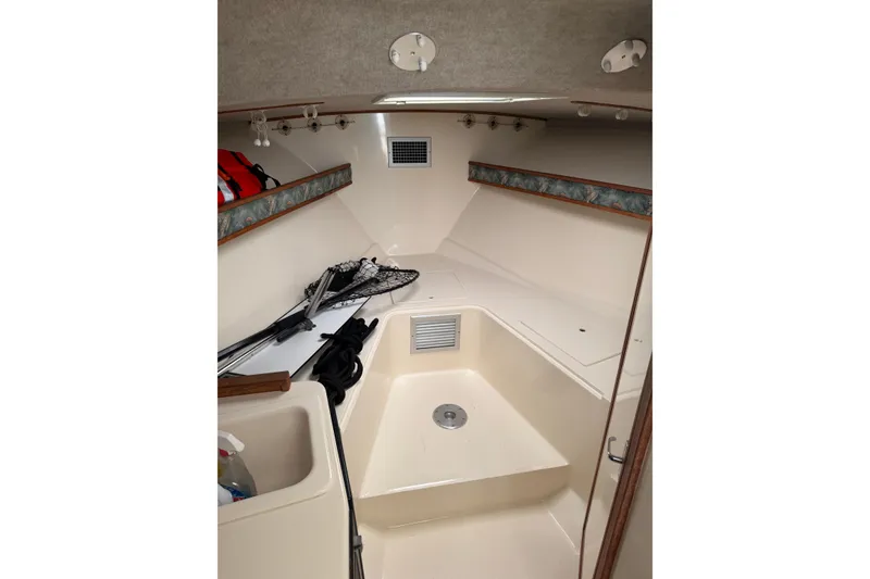Slide: The Image of 2006 Carolina Classic 28 cabin interior with fishing gear and storage space. - 6