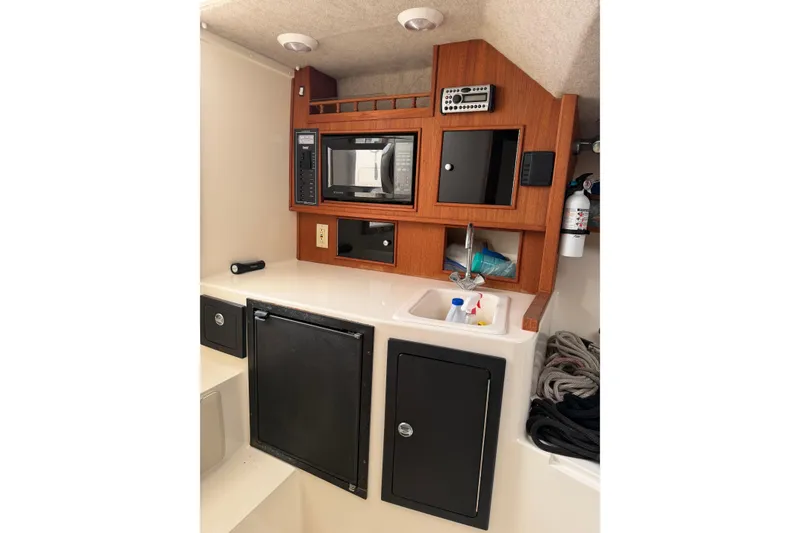 Slide: The Image of 2006 Carolina Classic 28 boat interior with kitchenette, microwave, and storage cabinets. - 7