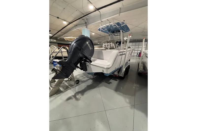 Slide: The Image of 2025 Sportsman Open 232 Center Console boat in showroom, featuring Yamaha outboard motor. - 15