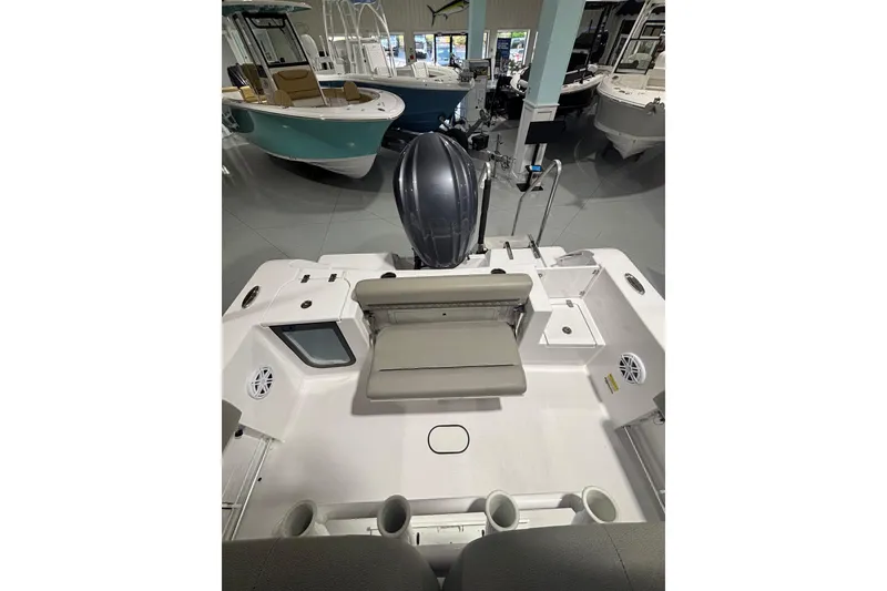 Slide: The Image of 2025 Sportsman Open 232 Center Console boat interior with seating and motor in showroom. - 21