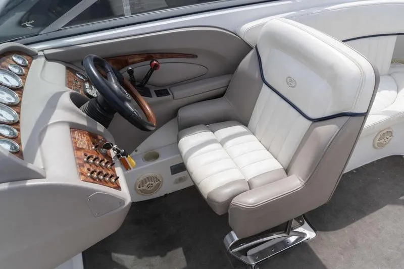 Slide: The Image of Interior of a 2002 Cobalt 262 boat featuring a luxurious captain's chair and dashboard. - 14