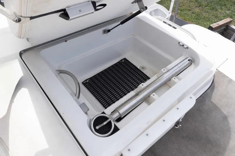 Slide: The Image of Open storage compartment on a 2002 Cobalt 262 boat, featuring a hydraulic lift. - 19