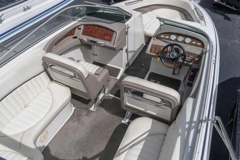 Slide: The Image of Interior of a 2002 Cobalt 262 boat with white seating and wood-accented dashboard. - 6