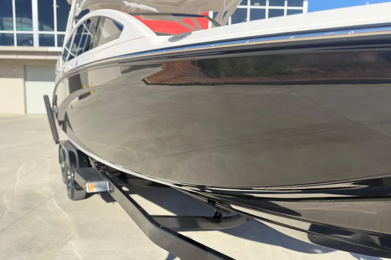 Slide: The Image of 2024 Yamaha Boats 275SD, sleek hull design, parked on trailer, outdoor setting. - 12