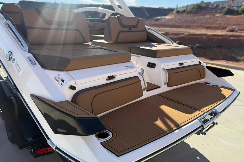 Slide: The Image of 2024 Yamaha Boats 275SD with luxurious seating and sleek design in sunlight. - 14