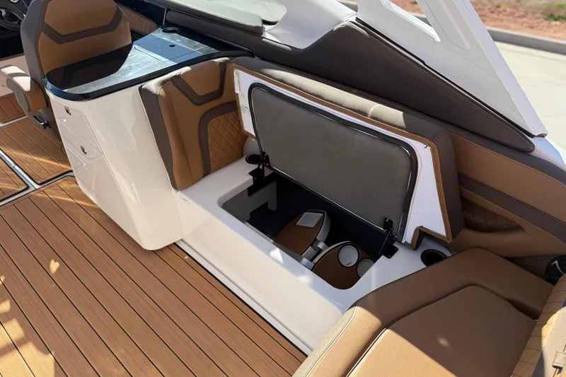 Slide: The Image of 2024 Yamaha Boats 275SD interior with open storage compartment and luxurious seating. - 17