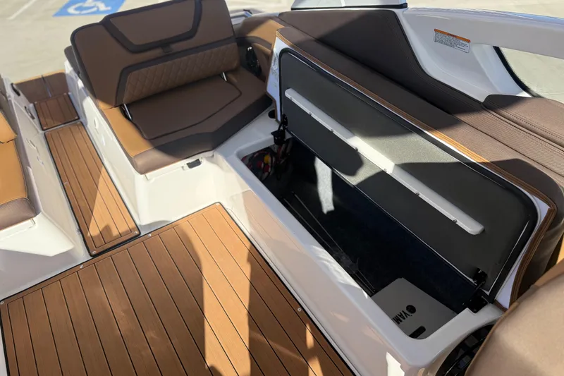 Slide: The Image of 2024 Yamaha Boats 275SD interior with open storage compartment and brown seating. - 18