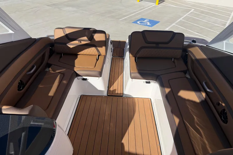 Slide: The Image of 2024 Yamaha Boats 275SD interior with brown seating and wood flooring. - 19