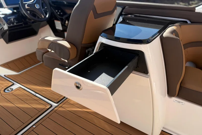 Slide: The Image of 2024 Yamaha Boats 275SD interior with open storage drawer and luxurious seating. - 23