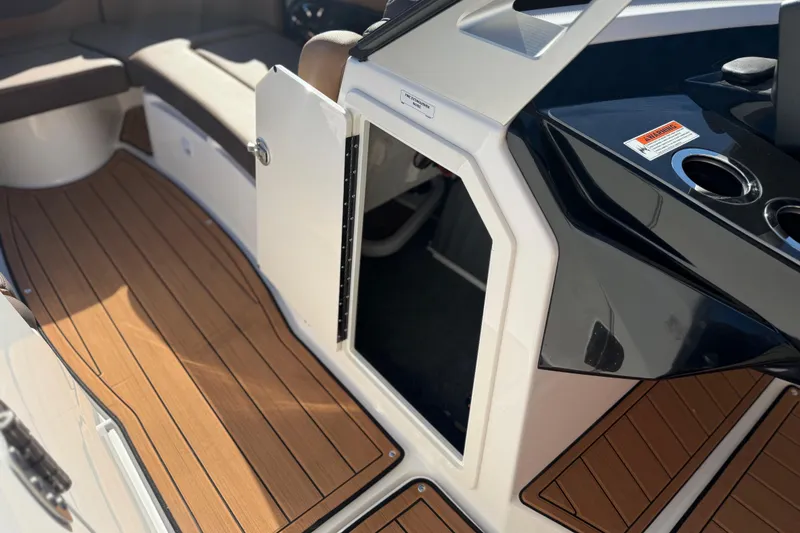 Slide: The Image of 2024 Yamaha Boats 275SD interior with open storage compartment and wood-style flooring. - 28