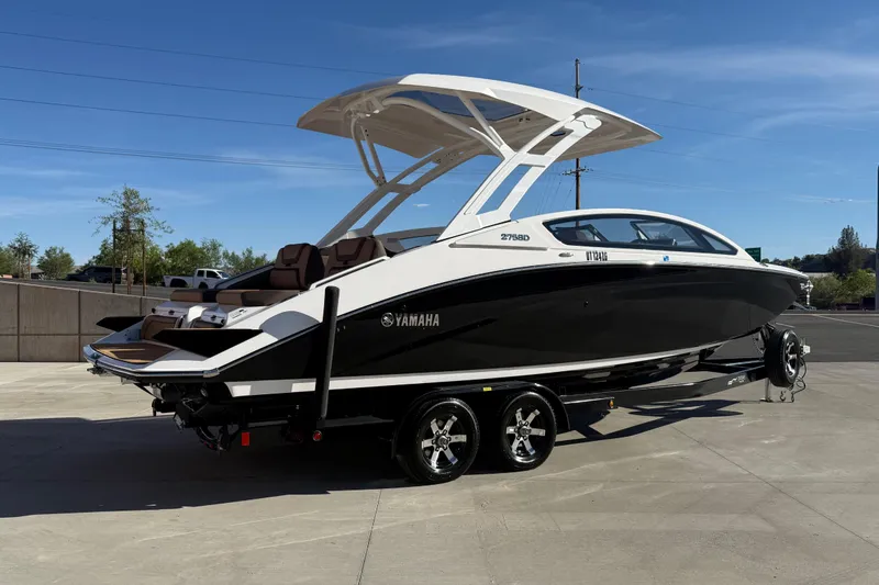 Slide: The Image of 2024 Yamaha Boats 275SD on trailer, sleek black and white design, parked outdoors. - 3