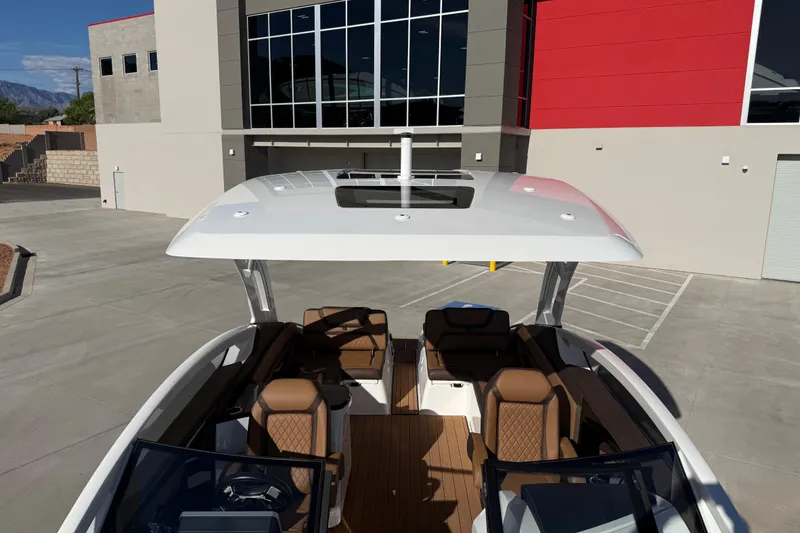 Slide: The Image of 2024 Yamaha Boats 275SD with spacious seating and sleek design, docked near modern building. - 33