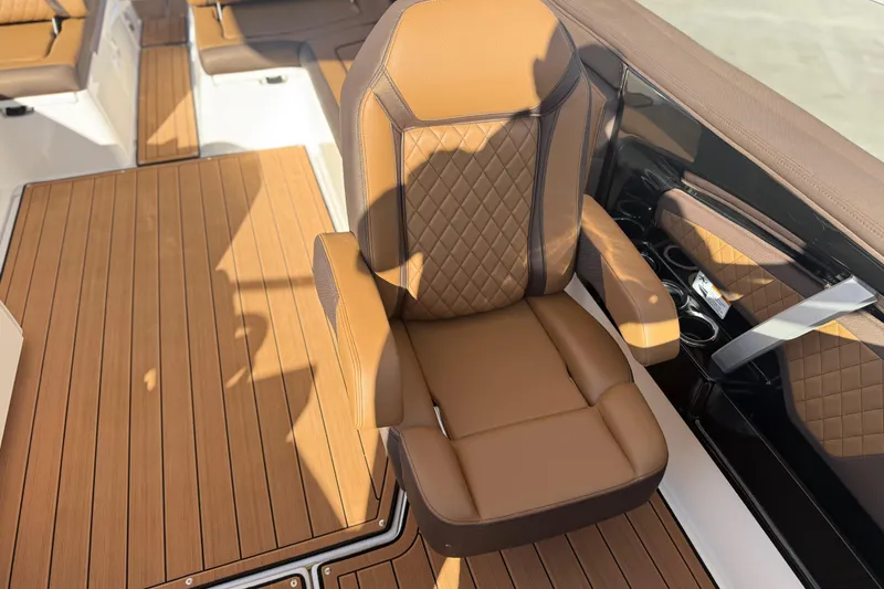 Slide: The Image of Luxurious seating on 2024 Yamaha Boats 275SD with elegant brown upholstery and wood-style flooring. - 36