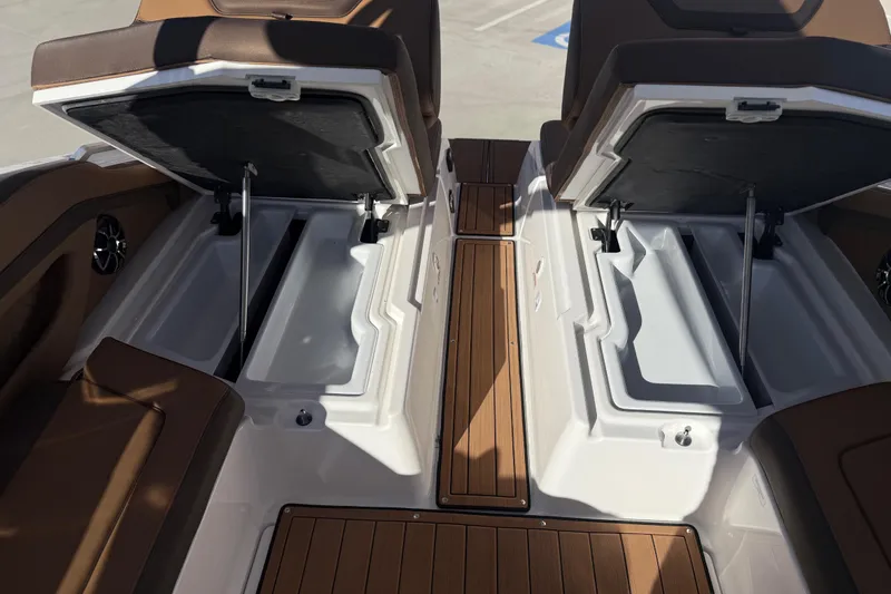 Slide: The Image of 2024 Yamaha Boats 275SD interior storage compartments with open lids and wooden flooring. - 37