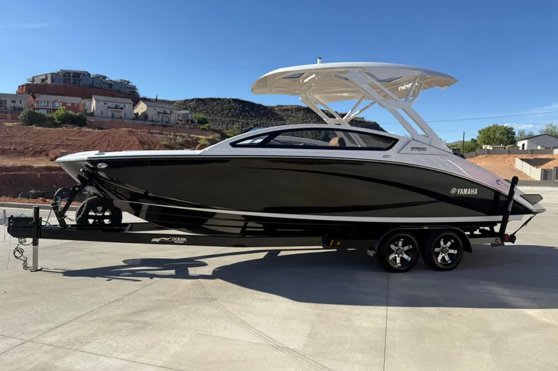 Slide: The Image of 2024 Yamaha Boats 275SD on trailer, sleek black design, parked outdoors. - 7