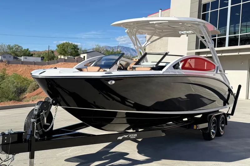 Slide: The Image of 2024 Yamaha Boats 275SD on trailer, sleek black design, parked outdoors. - 8