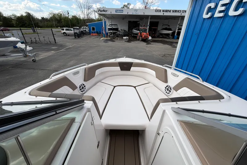 Slide: The Image of 2021 Chaparral 23 SSi boat interior with spacious seating at a marine service center. - 10