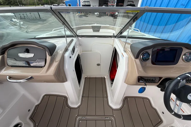 Slide: The Image of 2021 Chaparral 23 SSi boat interior with dashboard, steering wheel, and storage compartments. - 12