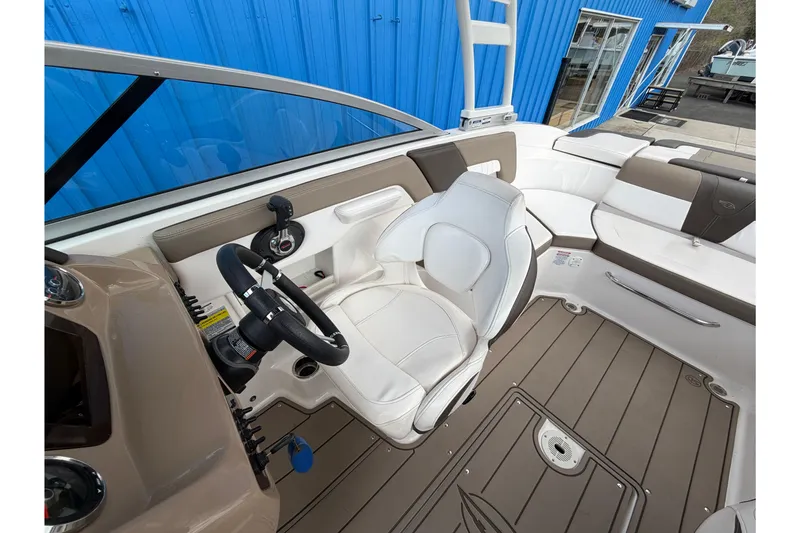 Slide: The Image of 2021 Chaparral 23 SSi boat interior with white seating and modern dashboard. - 16