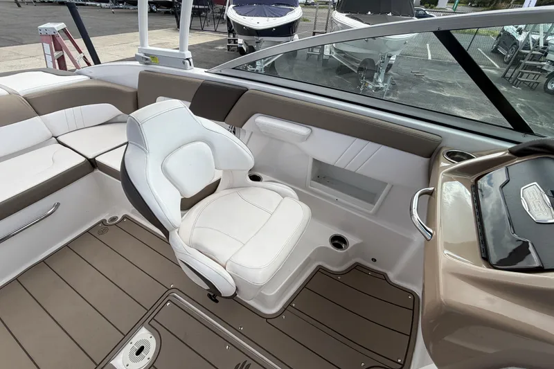 Slide: The Image of 2021 Chaparral 23 SSi boat interior with white seating and modern dashboard design. - 18