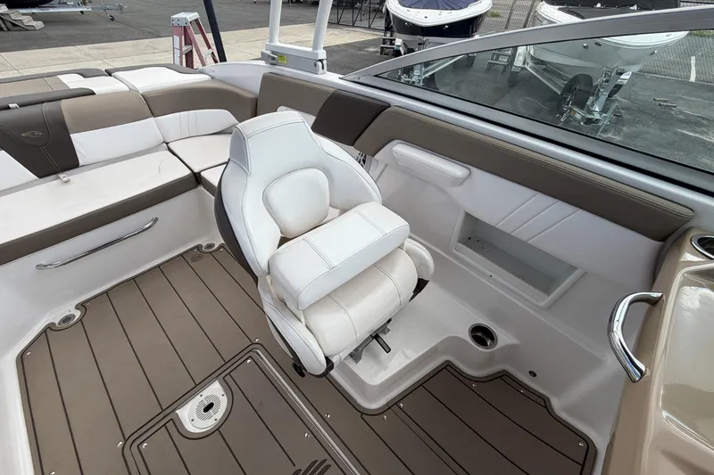 Slide: The Image of 2021 Chaparral 23 SSi boat interior with white and brown seating. - 19