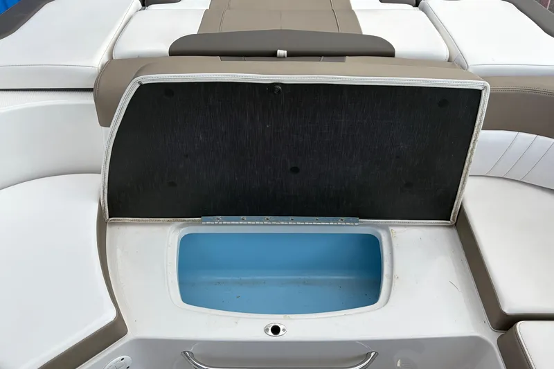 Slide: The Image of Open storage compartment on 2021 Chaparral 23 SSi boat, featuring cushioned seating. - 26