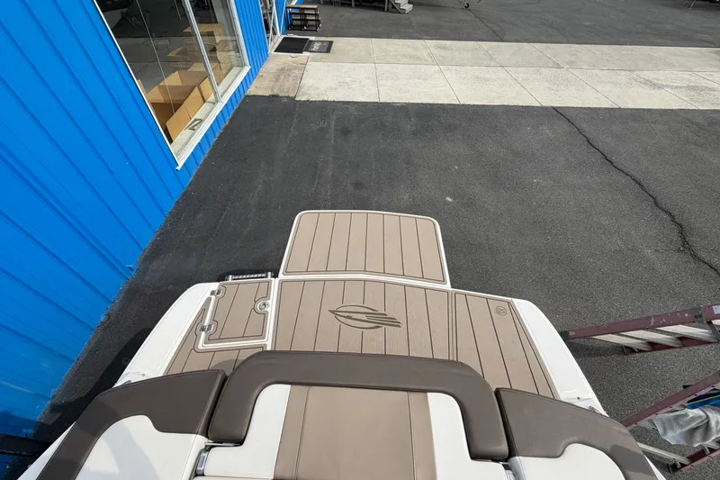 Slide: The Image of 2021 Chaparral 23 SSi boat deck near blue building and asphalt pavement. - 29